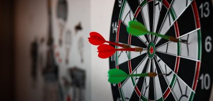 Close-up of a dartboard with multiple darts hitting the target, emphasizing precision and focus.