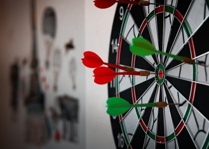 Close-up of a dartboard with multiple darts hitting the target, emphasizing precision and focus.